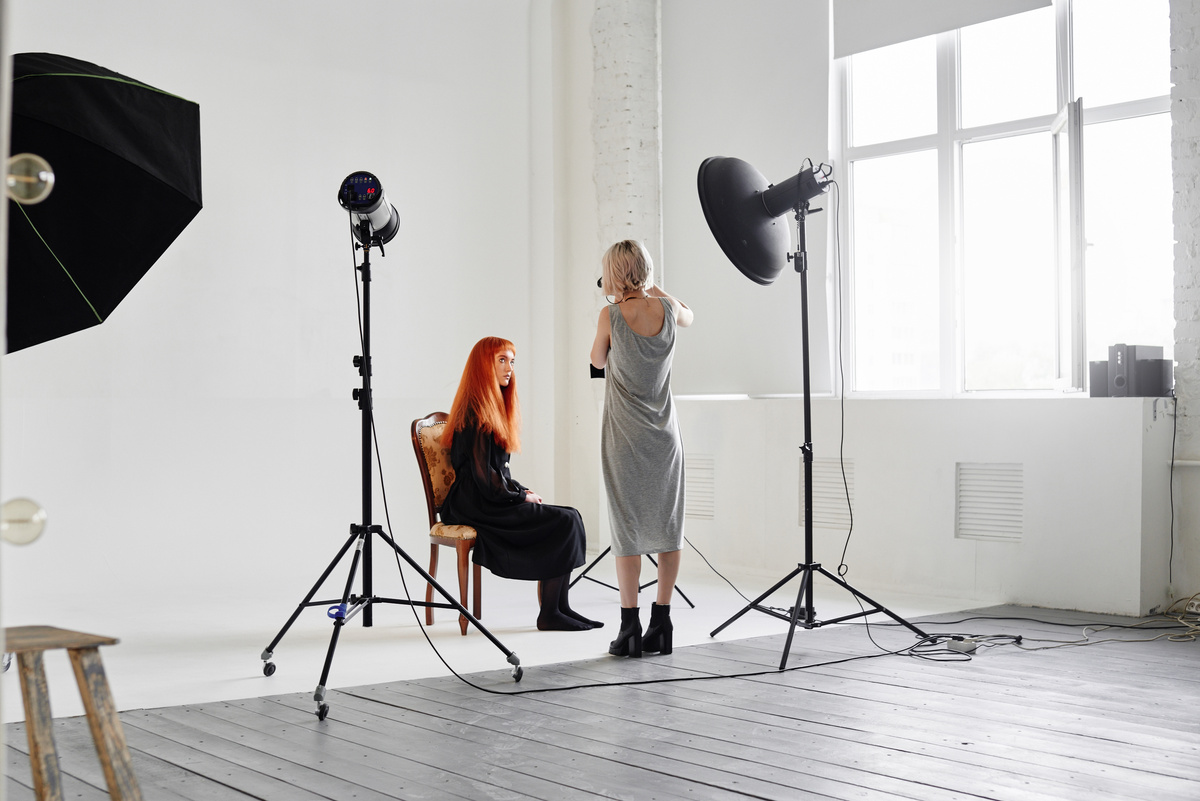 Girl photographer photographing fashion models  in Studio